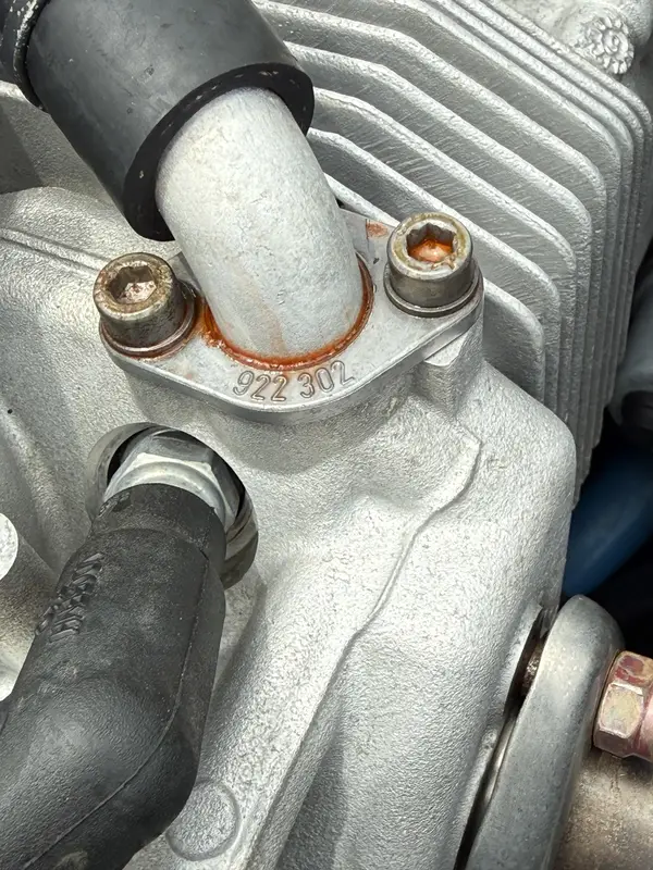 Coolant residue near a ROTAX cylinder head traced through the hose and fitting area