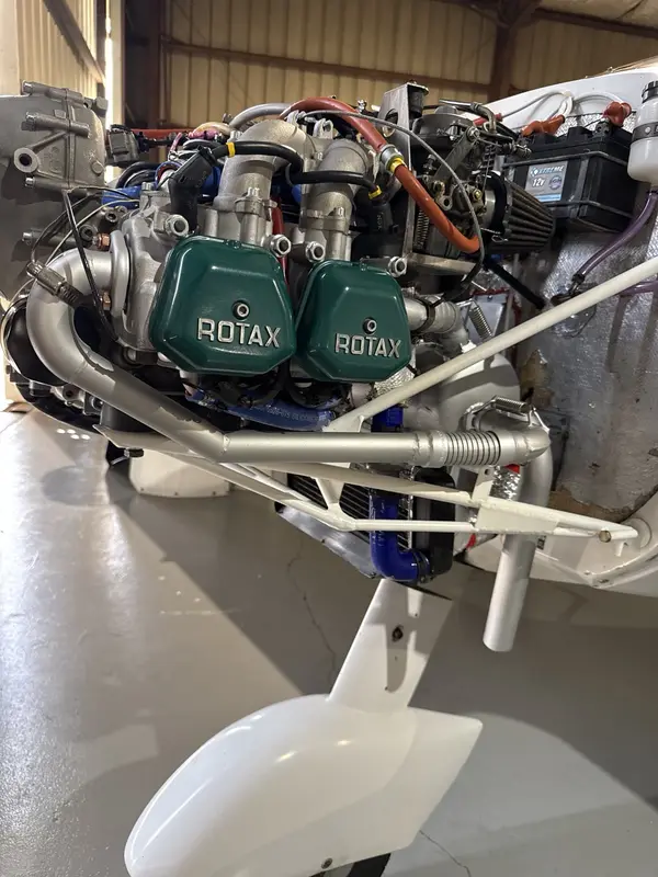 Installed Rotax engine showing induction, wiring, hoses, surrounding systems, and service access