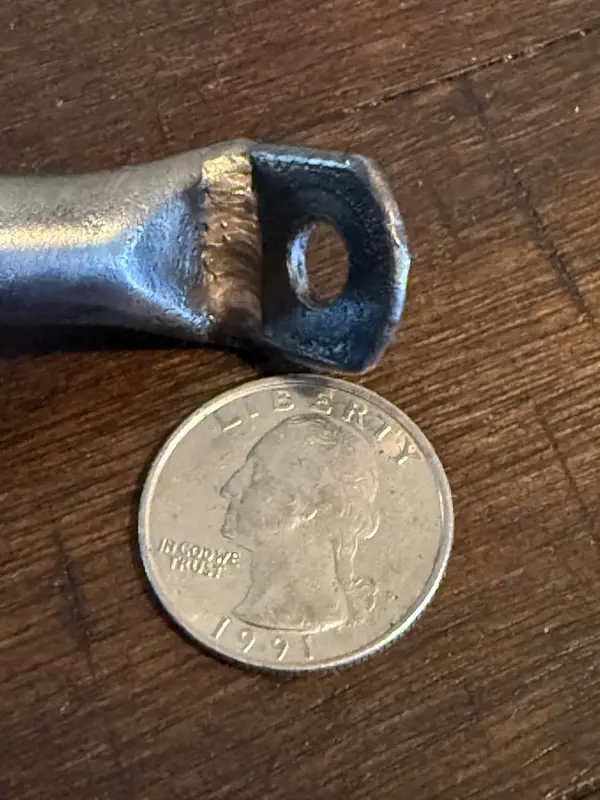 Engine cage weld detail photographed with a quarter for scale