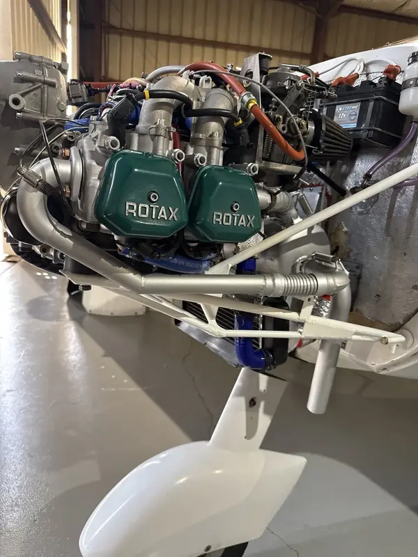 Installed ROTAX engine with surrounding airframe, wiring, and hose context